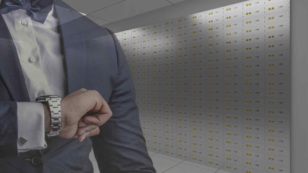 A man in suite looking at his watch in a safe deposit centre